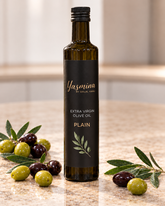 Yasmina by Dalal Kanj certified organic plain extra virgin olive oil, dark glass bottle surrounded by fresh green and black olives and olive branch